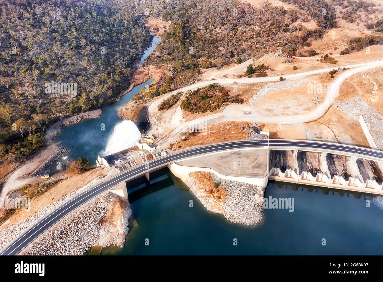 Diga di generazione di energia elettrica sul fiume Snowy nelle montagne innevate dell'Australia - Lago Jindabyne. Vista aerea dall'alto verso il basso su cancello e canale di scarico. Foto Stock