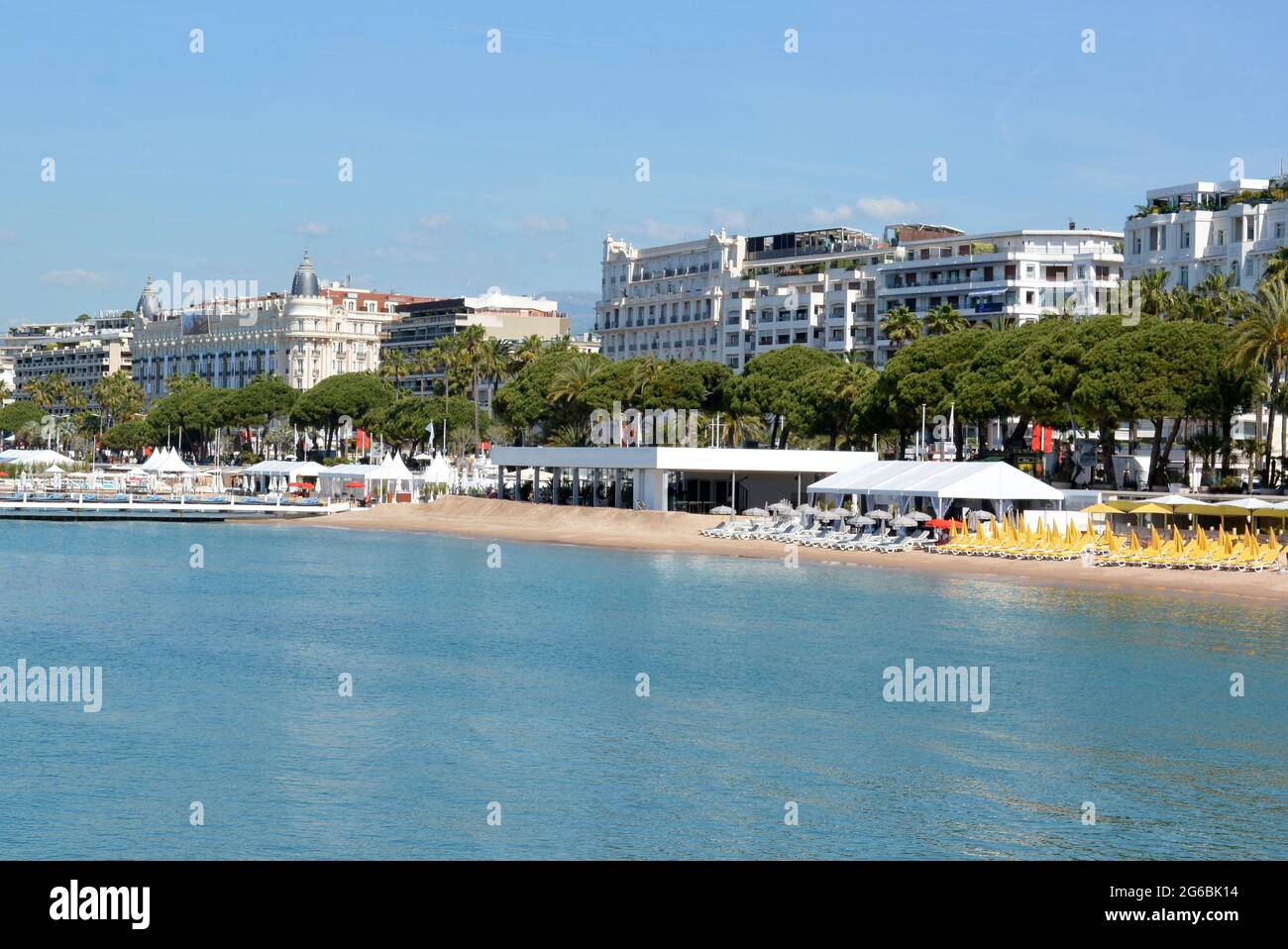Francia, Cannes, Boulevard Croisette, hotel di lusso, spiagge di sabbia con ombrelloni multicolore e lettini. Foto Stock