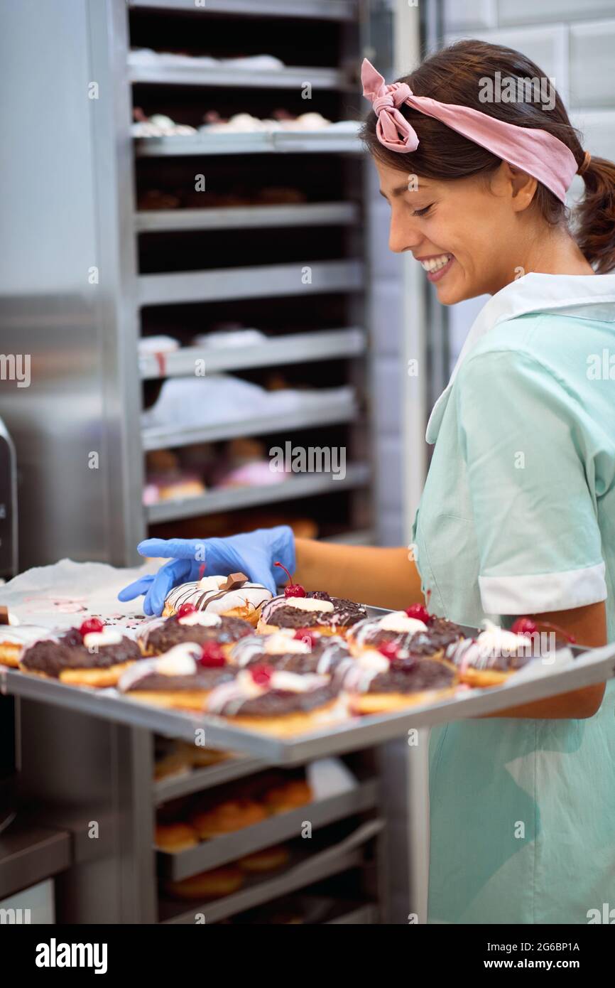 Il proprietario di piccola impresa è appassionato circa il suo prodotto/ciambelle Foto Stock