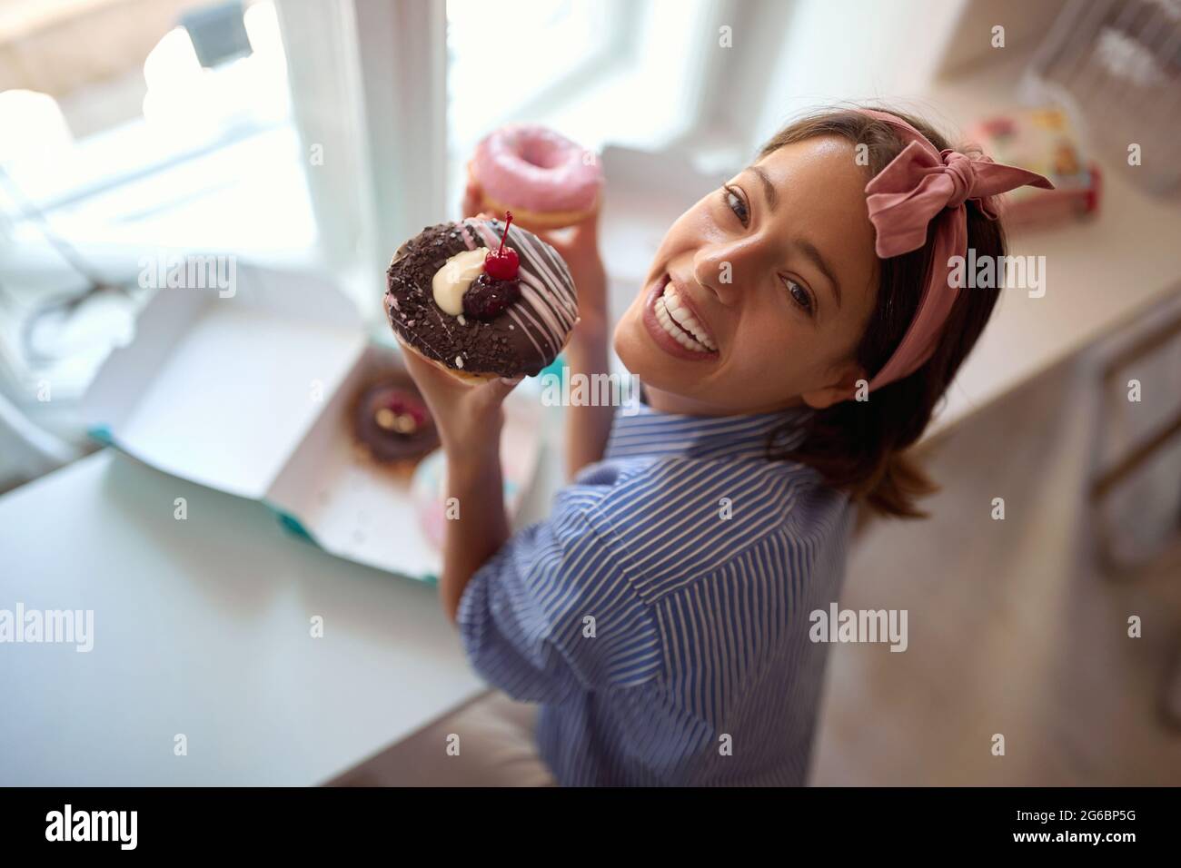 Il proprietario di piccola impresa è appassionato circa il suo prodotto/ciambelle allettante Foto Stock