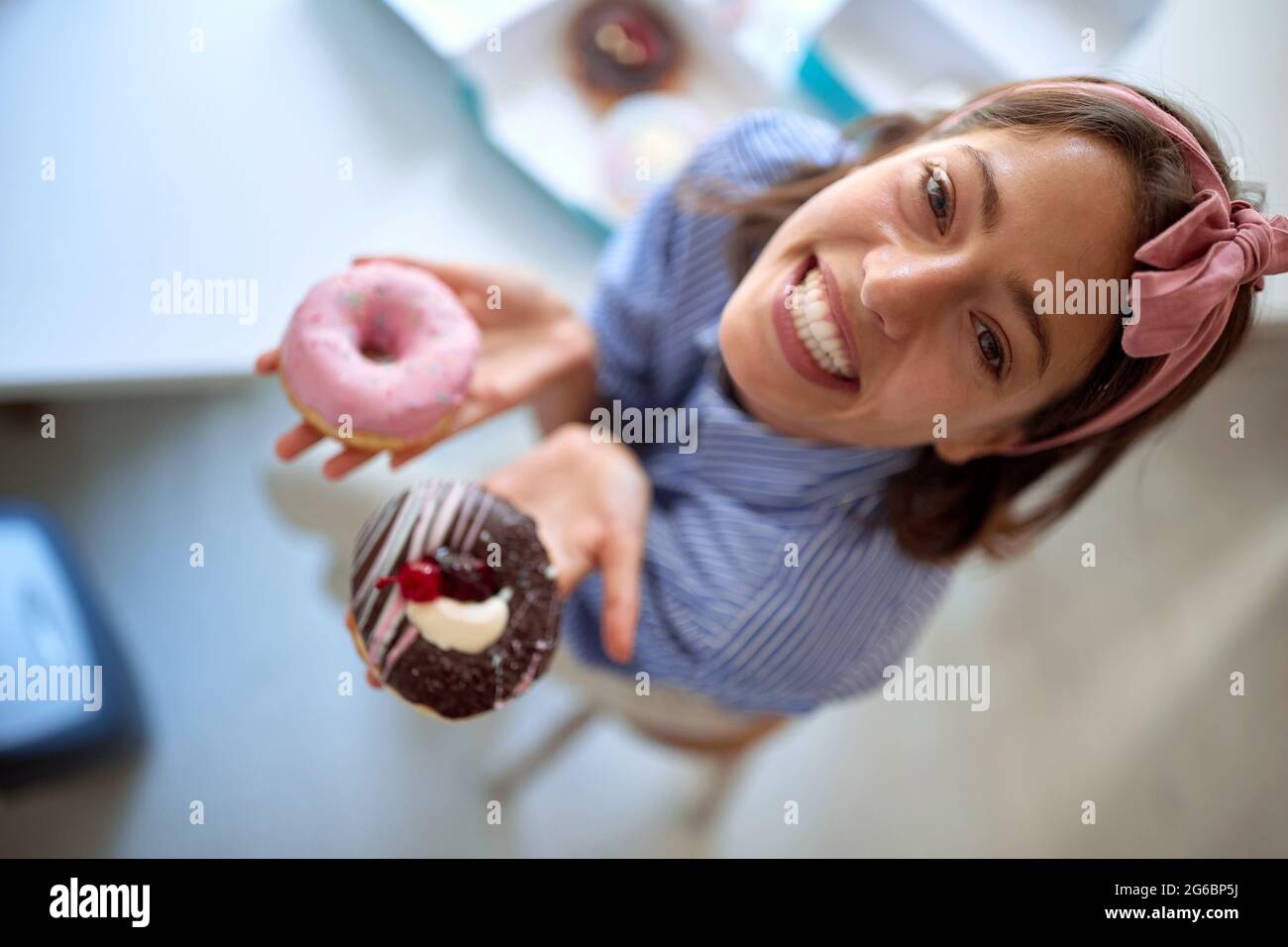 Il proprietario di piccola impresa è appassionato circa il suo prodotto/ciambelle yummy Foto Stock