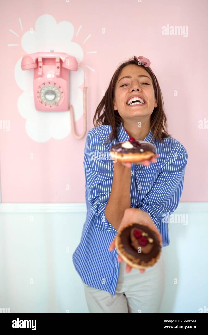 Il proprietario di piccola impresa è appassionato circa il suo prodotto/ciambelle delizioso Foto Stock