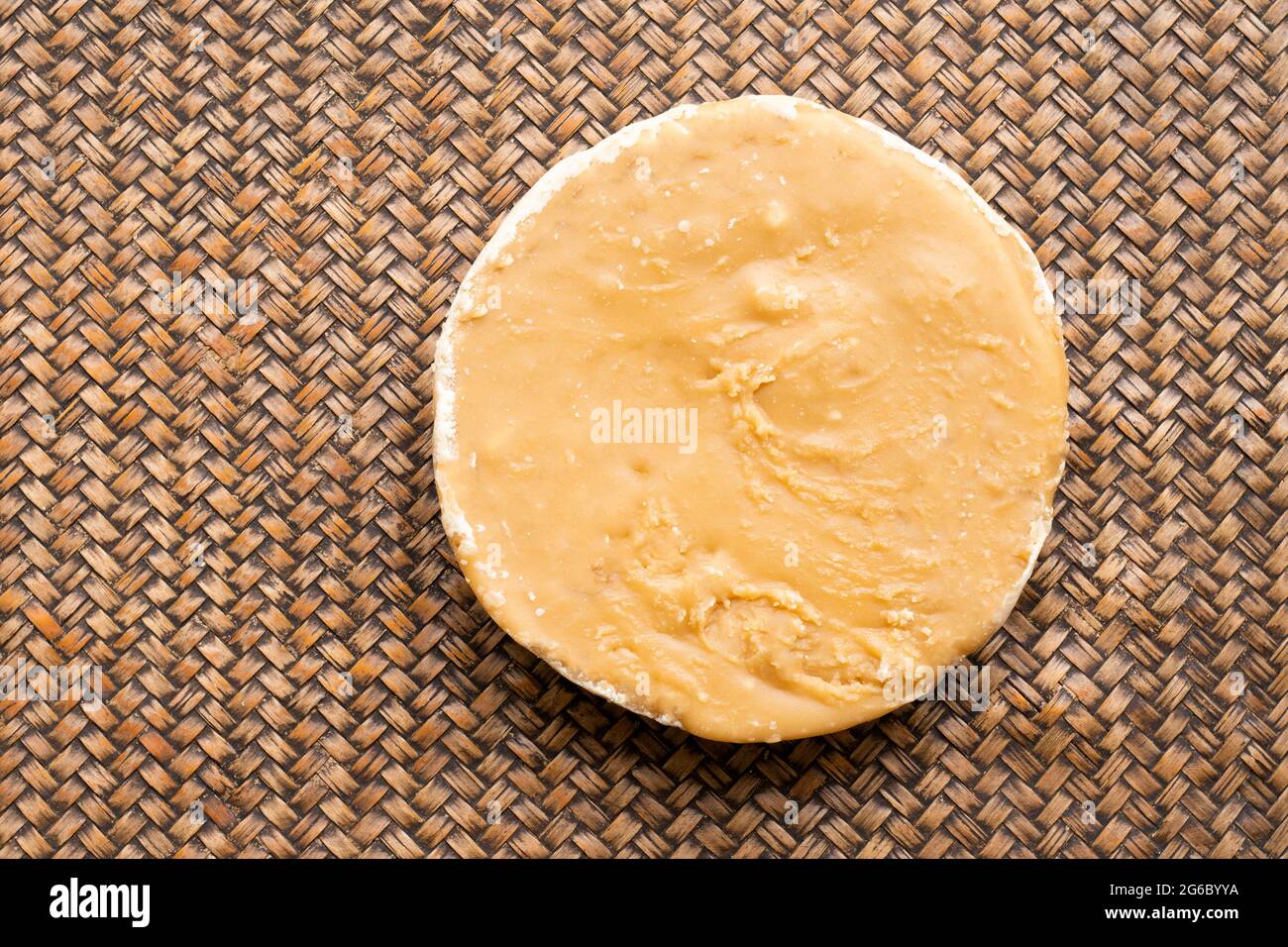 La forma circolare dello zucchero di cocco ha un colore marrone chiaro, su sfondo bianco. Spazio di copia. Spazio di copia. Foto Stock