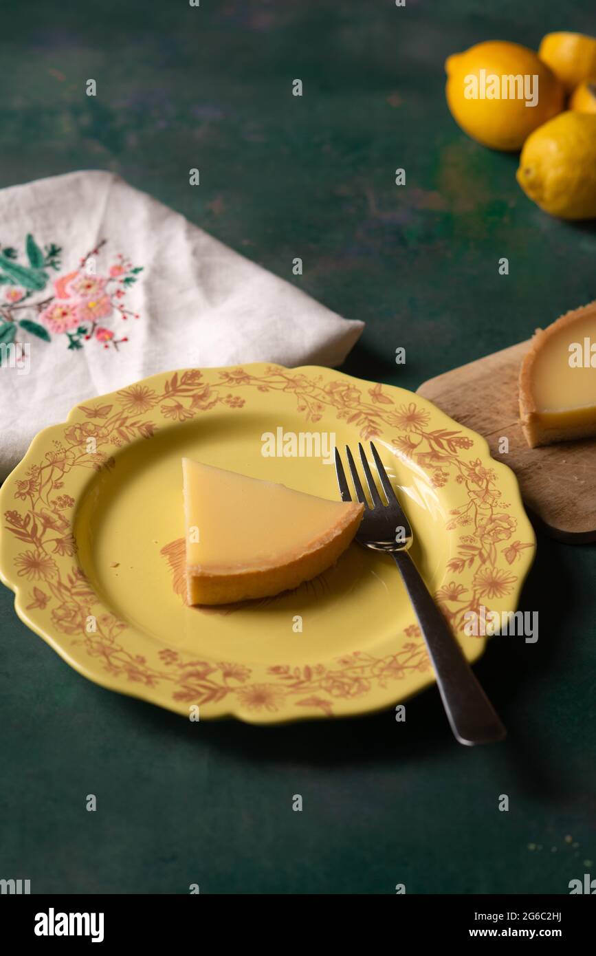 Dessert estivo di torta al limone cotta in casa su sfondo scuro Foto Stock