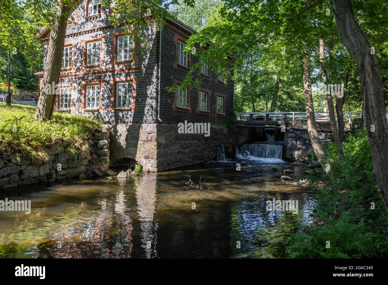 Il fiume idilliaco e il Mulino nel villaggio di Fiskars, una storica zona di ferri e popolare destinazione di viaggio. Foto Stock