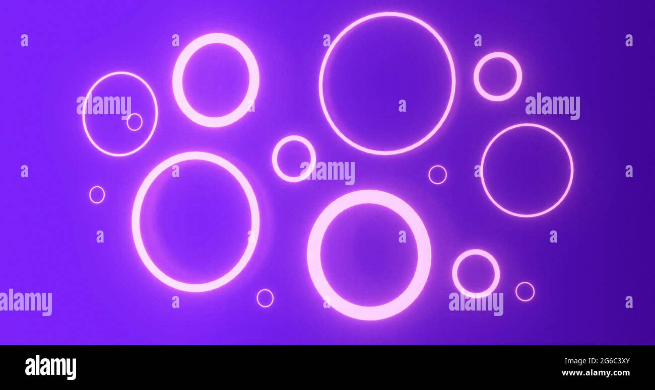 Anelli al neon rosa pulsante di varie dimensioni che si illuminano su sfondo viola Foto Stock