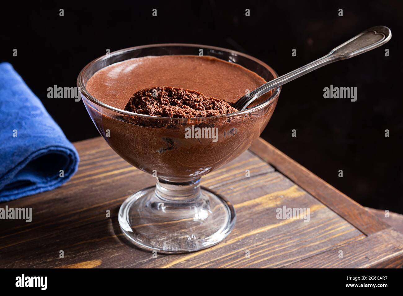 Mousse al cioccolato francese tradizionale in una ciotola trasparente su sfondo di legno scuro Foto Stock