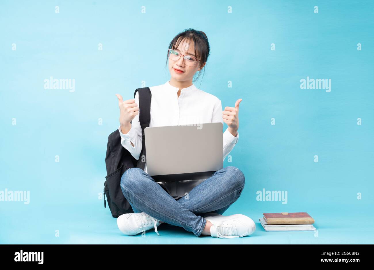Ritratto di una bella studentessa su sfondo blu Foto Stock