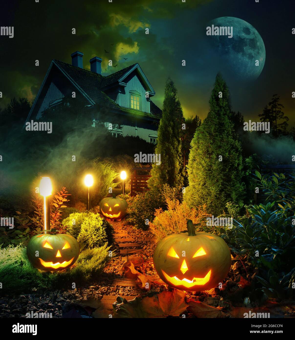 Scena notturna di Halloween lanterne di zucca percorso attraverso mistero giardino a spaventosa casa infestata Foto Stock