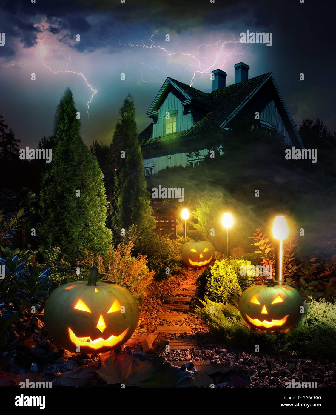 Temporale la sera di Halloween, lanterne di zucca percorso attraverso mistero giardino a casa spaventoso infestato Foto Stock