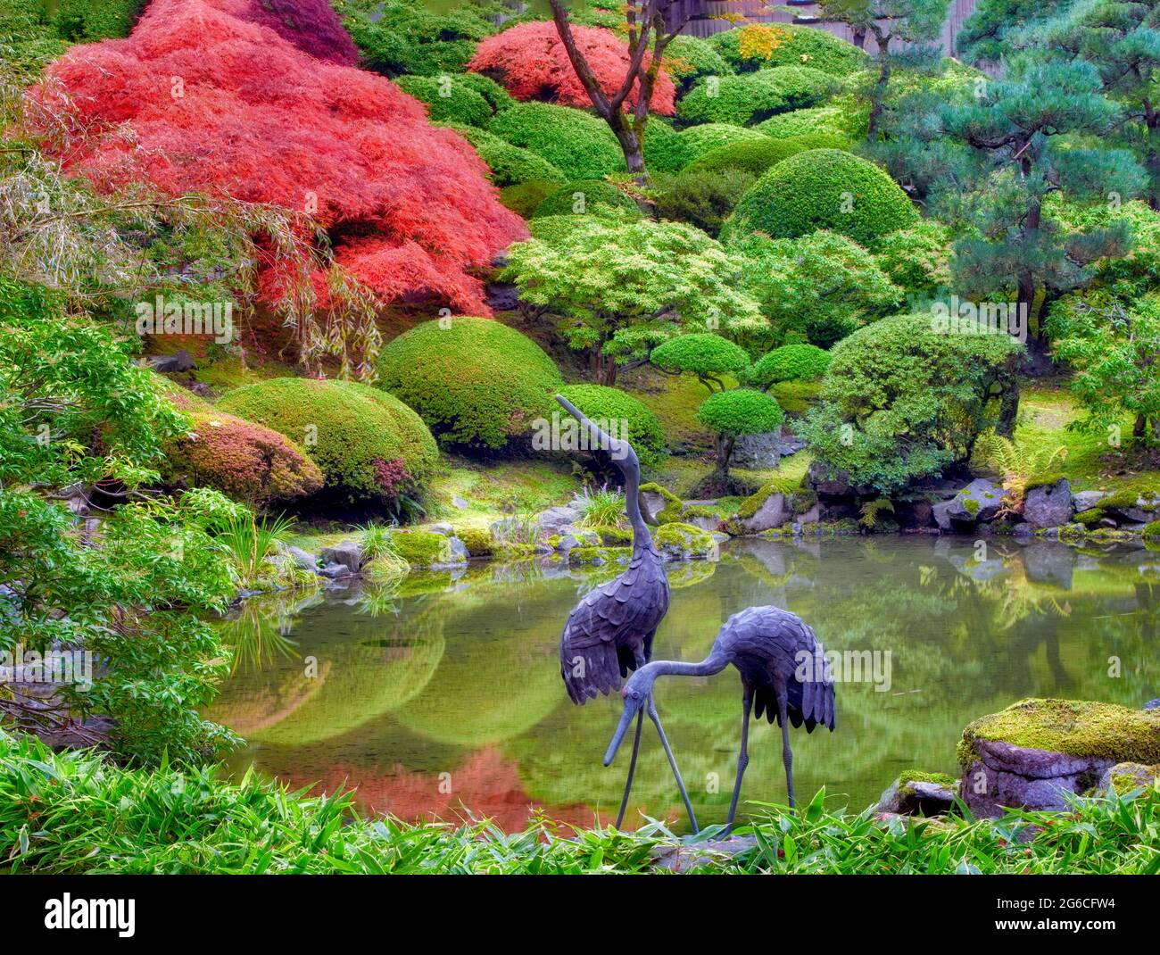 Scultura e stagno con Autunno a colori. Portland Giardini Giapponesi. Oregon Foto Stock