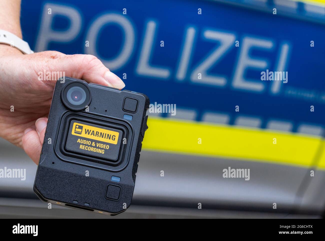 Schwerin, Germania. 05 luglio 2021. Durante la presentazione del sistema, davanti a un'auto della polizia viene tenuta una nuova camma del corpo. Per la polizia di Meclemburgo-Pomerania occidentale, le telecamere per registrazioni di film e audio fanno ora parte delle attrezzature standard delle pattuglie di polizia nelle città più grandi. Nel 2018/19, le camme della carrozzeria sono state testate per sette mesi nell'ambito di un progetto pilota. Credit: Jens Büttner/dpa-Zentralbild/dpa/Alamy Live News Foto Stock