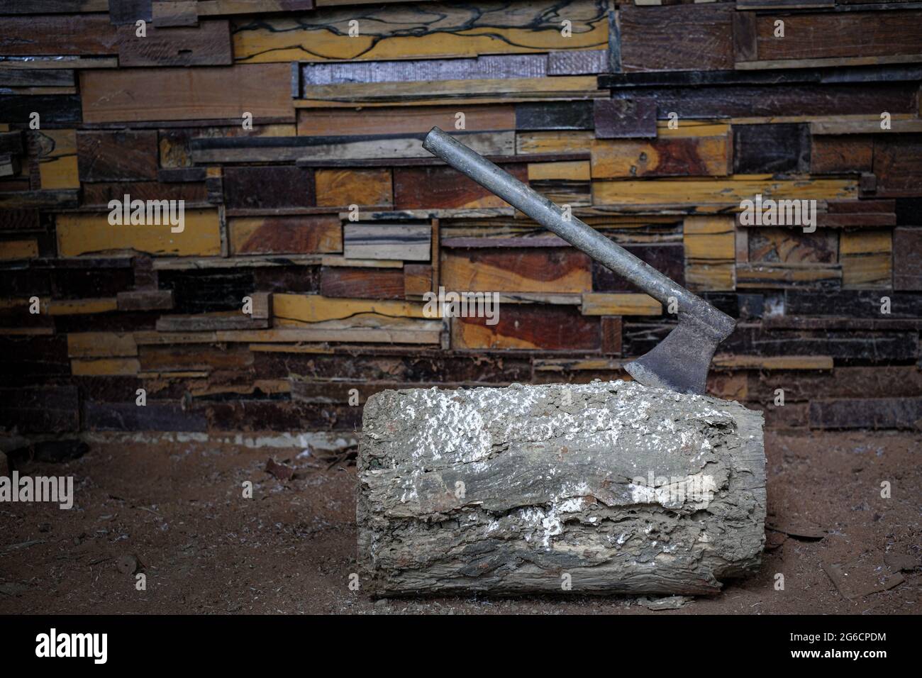 L'ascia di metallo vecchia con il bloccato in un ceppo alle pareti è fatta di tipi differenti di sfondo di tessitura del legno Foto Stock