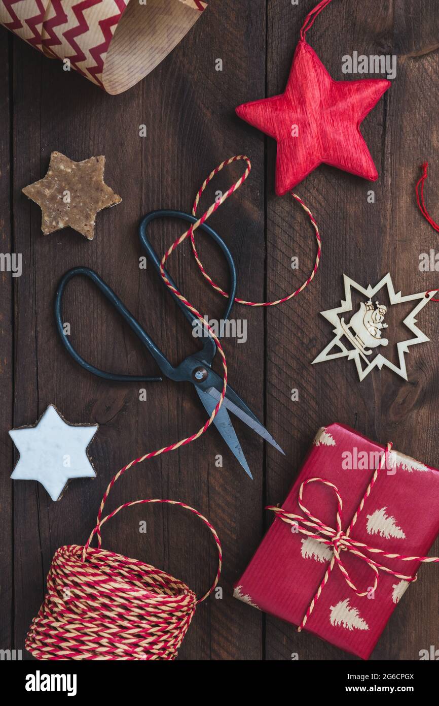 Vista dall'alto sulla scena regalo di natale con regalo, nastro, carta, biscotti e decorazioni Foto Stock