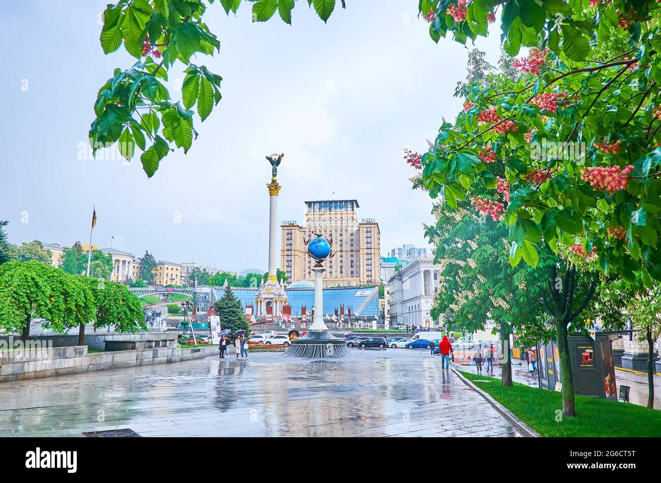 KYIV, UCRAINA - 18 MAGGIO 2021: Piazza Maidan Nezalezhnosti con alberi di castagno-cavalli rossi fioriscono, Monumento Globe, Monumento dell'Indipendenza e Hotel Ucraina Foto Stock