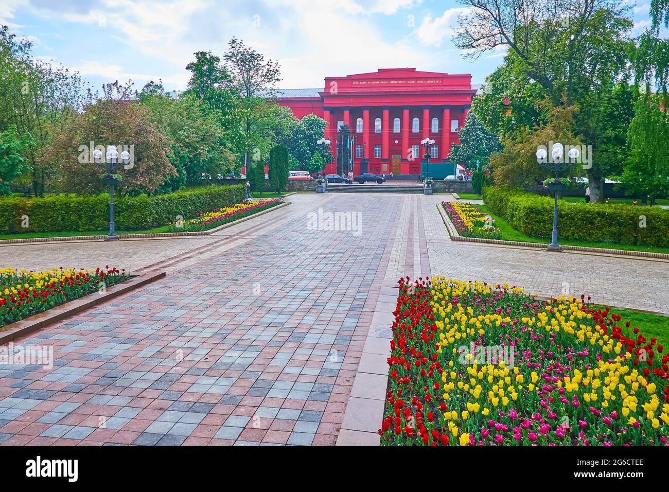 Il corpo centrale rosso dell'Università Nazionale di Kiev, visto dal parco panoramico di Taras Shevchenko con aiuole colorate, Kyiv, Ucraina Foto Stock