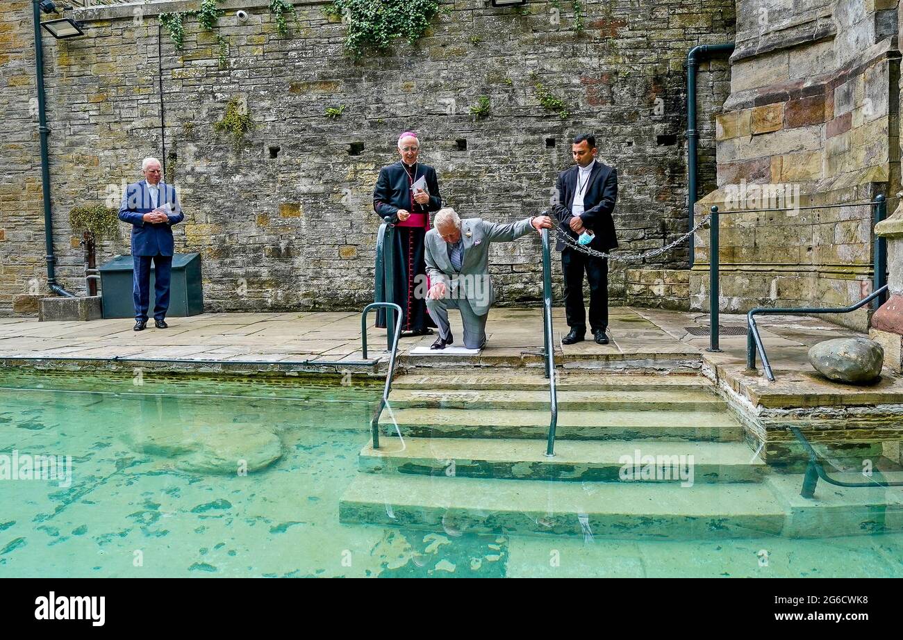 Il Principe di Galles (seconda a destra) tocca l'acqua curativa durante una visita al pozzo di San Winefride, nel Flintshire, nel Galles del nord, come Signore-tenente di Clwyd, Henry Fetherstonhaugh (a sinistra), Vescovo di Wrexham Peter Brignall (seconda a sinistra) e Parroco cattolico romano di Holywell, Padre Justin Karakadu (a destra), Nel popolare luogo di pellegrinaggio cattolico, come parte di un tour di una settimana del Galles per la settimana del Galles. Data immagine: Lunedì 5 luglio 2021. Foto Stock