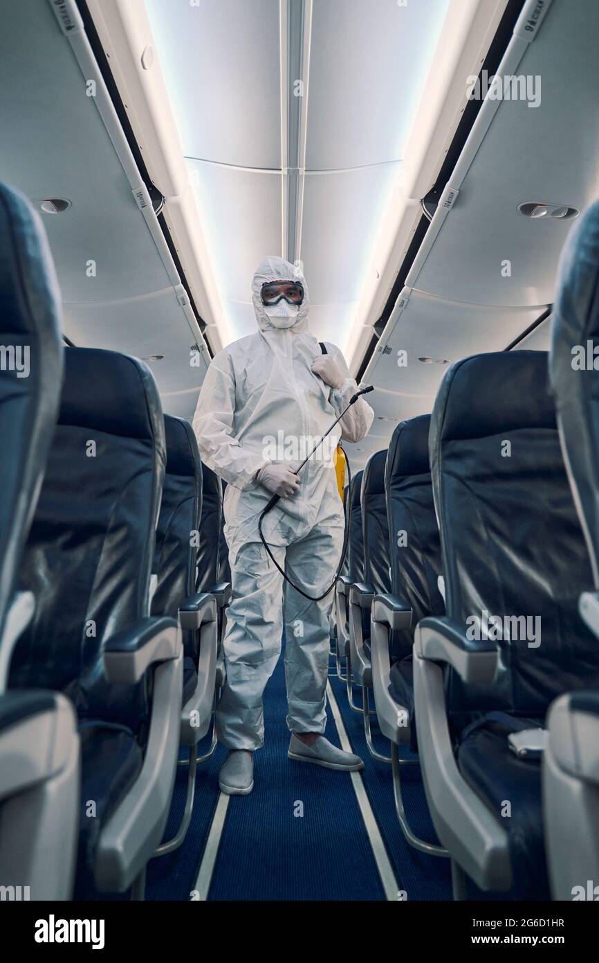 Uomo in occhiali di protezione e guanti in nitrile guardando avanti Foto Stock