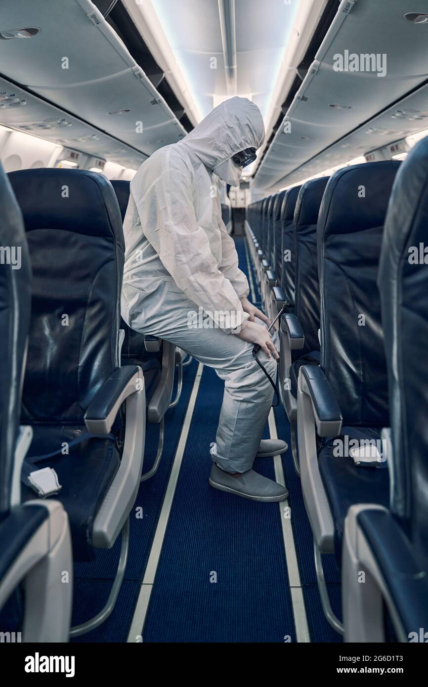 Uomo in un equipaggiamento di protezione in appoggio dopo la disinfezione dell'abitacolo Foto Stock