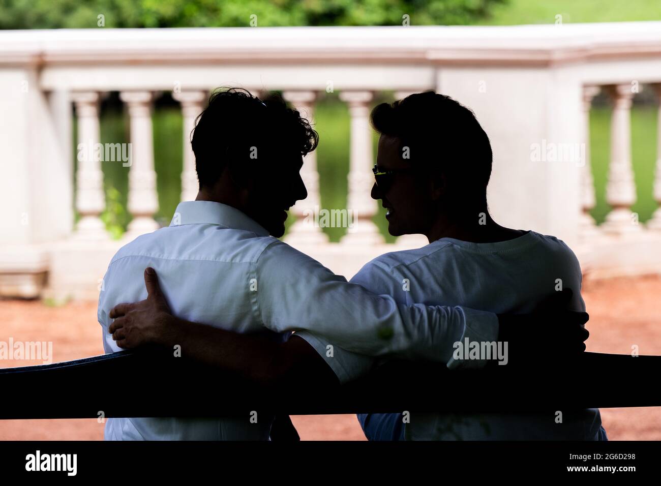 Oldenburg, Germania. 03 luglio 2021. ILLUSTRAZIONE - due uomini siedono insieme il braccio su un banco di stazionamento. (Posed scene) Credit: Mohssen Assanimoghaddam/dpa - ATTENZIONE: Solo per reportistica editoriale e uso solo in formato completo. Nessuna modifica delle immagini (le profondità dell'immagine non devono essere illuminate, gli uomini devono rimanere irriconoscibili)./dpa/Alamy Live News Foto Stock