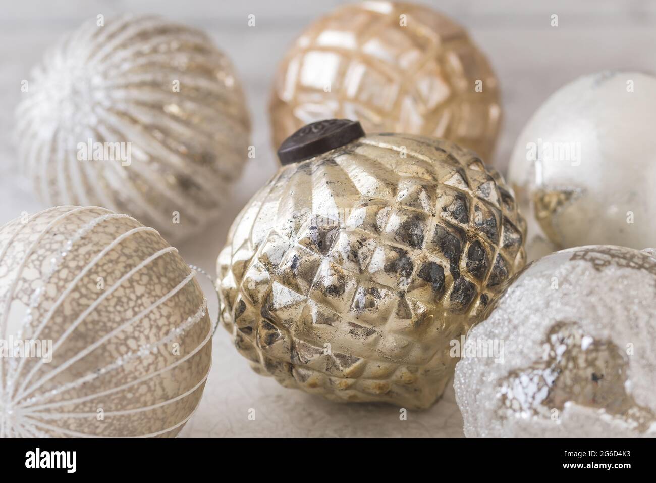 Oro e argento scintillanti baubles natalizi strutturati su sfondo bianco Foto Stock