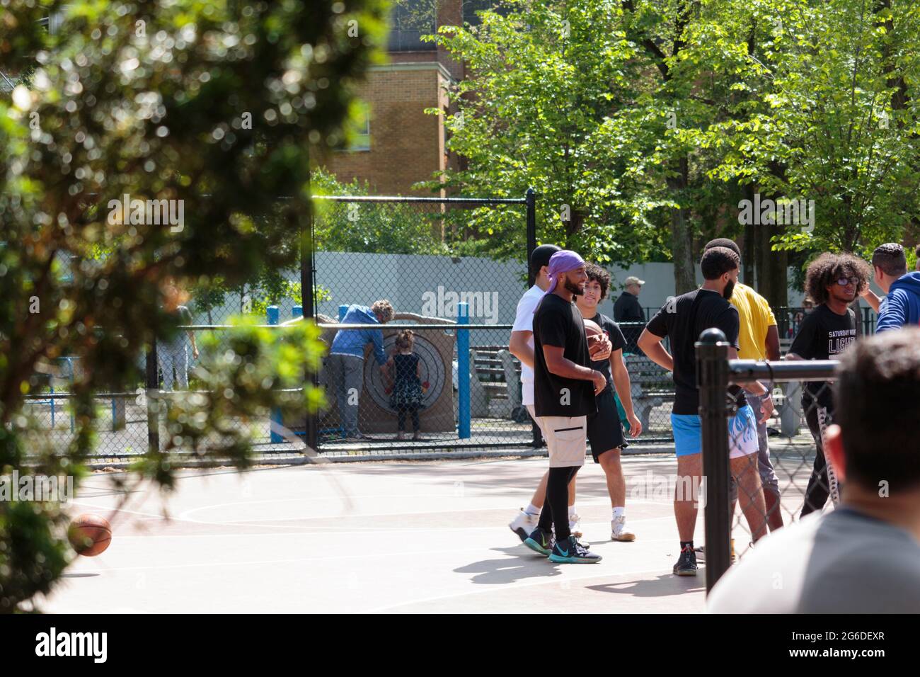gruppo di uomini afroamericani su un campo di pallacanestro della città, ridendo e sorridendo, nella città di new york Foto Stock