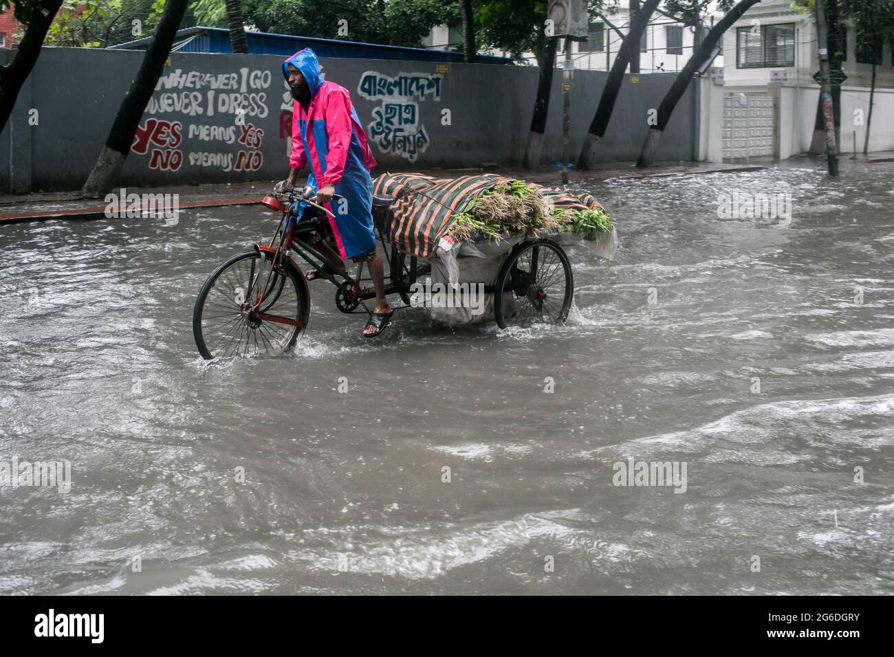 Dhaka, Bangladesh. 04 luglio 2021. Un ciclista fa la sua strada durante una pioggia. Il paese è entrato in un blocco rigoroso e pesante monsone downpour ha causato il disboscamento estremo di acqua nella maggior parte delle zone della città di Dhaka, il Bangladesh. Le strade sono state sommerse rendendo la marcia lenta e pericolosa. Credit: SOPA Images Limited/Alamy Live News Foto Stock