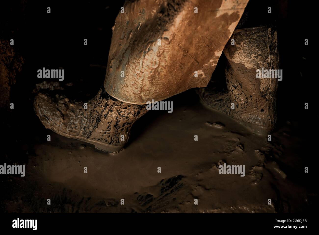 Una vista sulle gambe di una donna anziana mentre si lavora su un tetto di argilla Foto Stock
