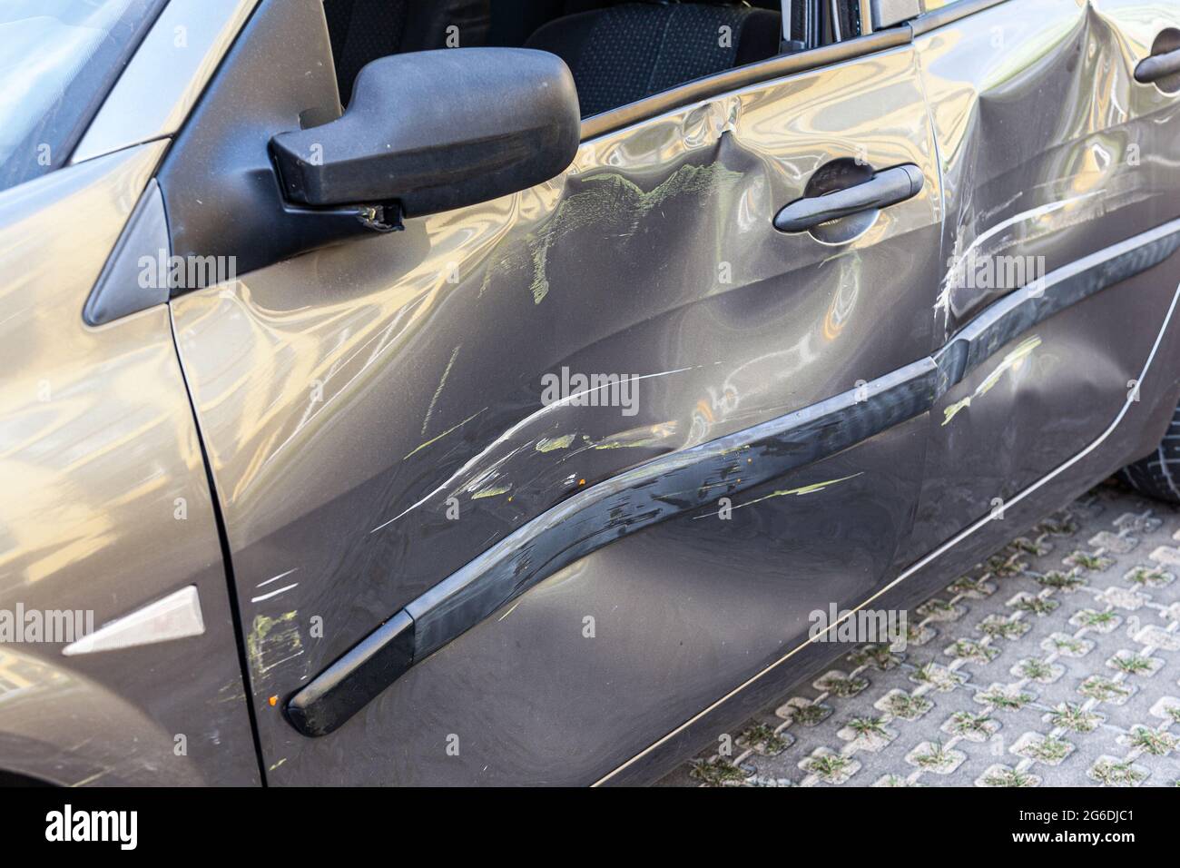 Auto rotta dopo incidente con graffi e ammaccature sulla porta, auto con carrozzeria rotta dopo emergenza, parti del veicolo distrutte. Esterno Sho Foto Stock