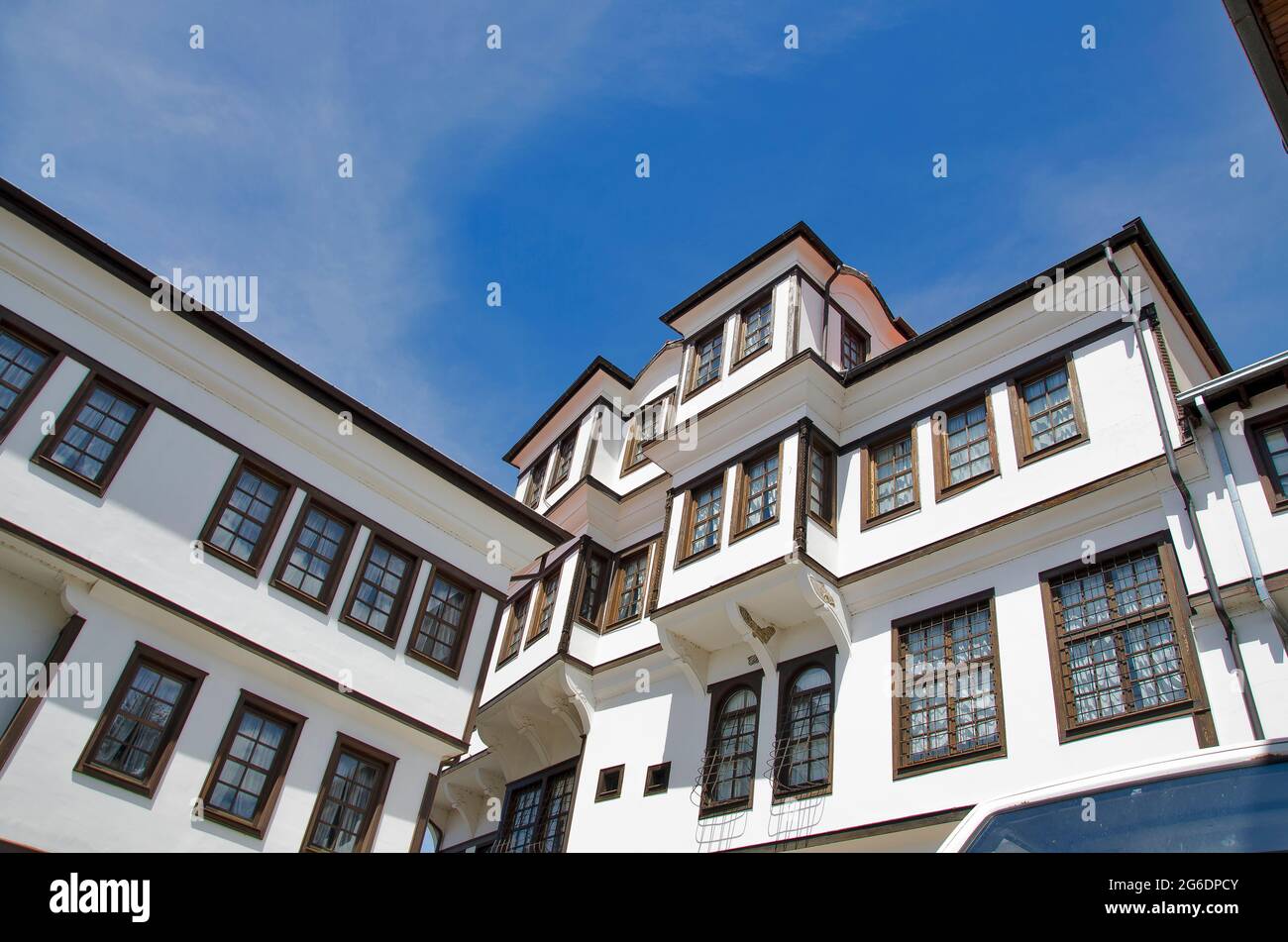 Abbandonato bianco vecchio stile casa vintage con finestre in legno su cielo blu chiaro Foto Stock