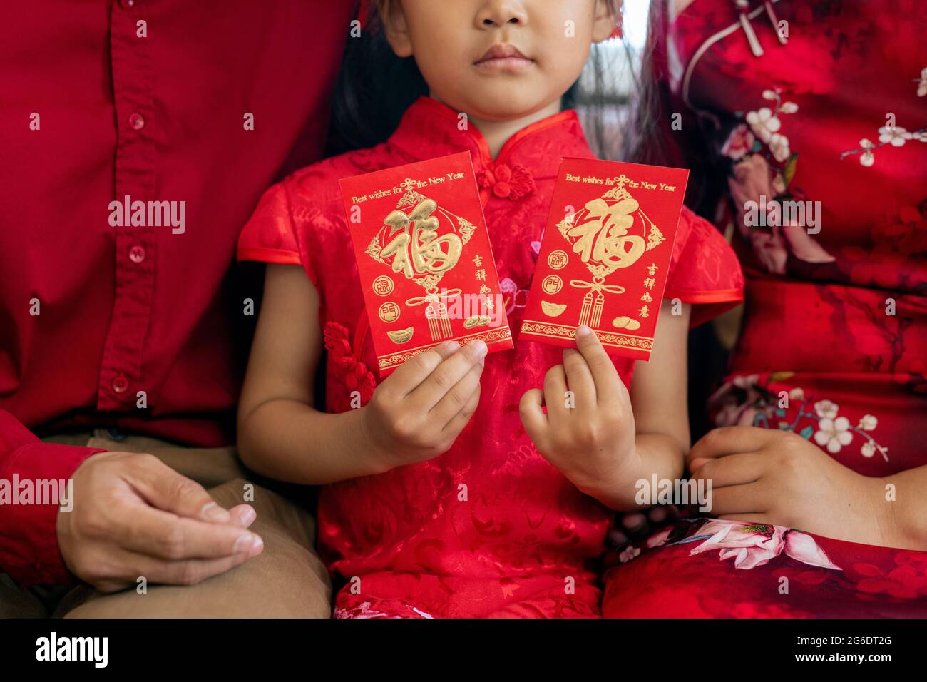 Carino bambino asiatico che tiene le cartoline rosse con i saluti sul Capodanno cinese Foto Stock