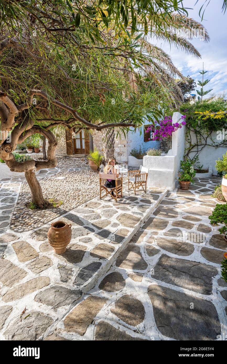 Cortile, casa greca, giovane donna che ha la prima colazione in vacanza fuori, Grecia Foto Stock