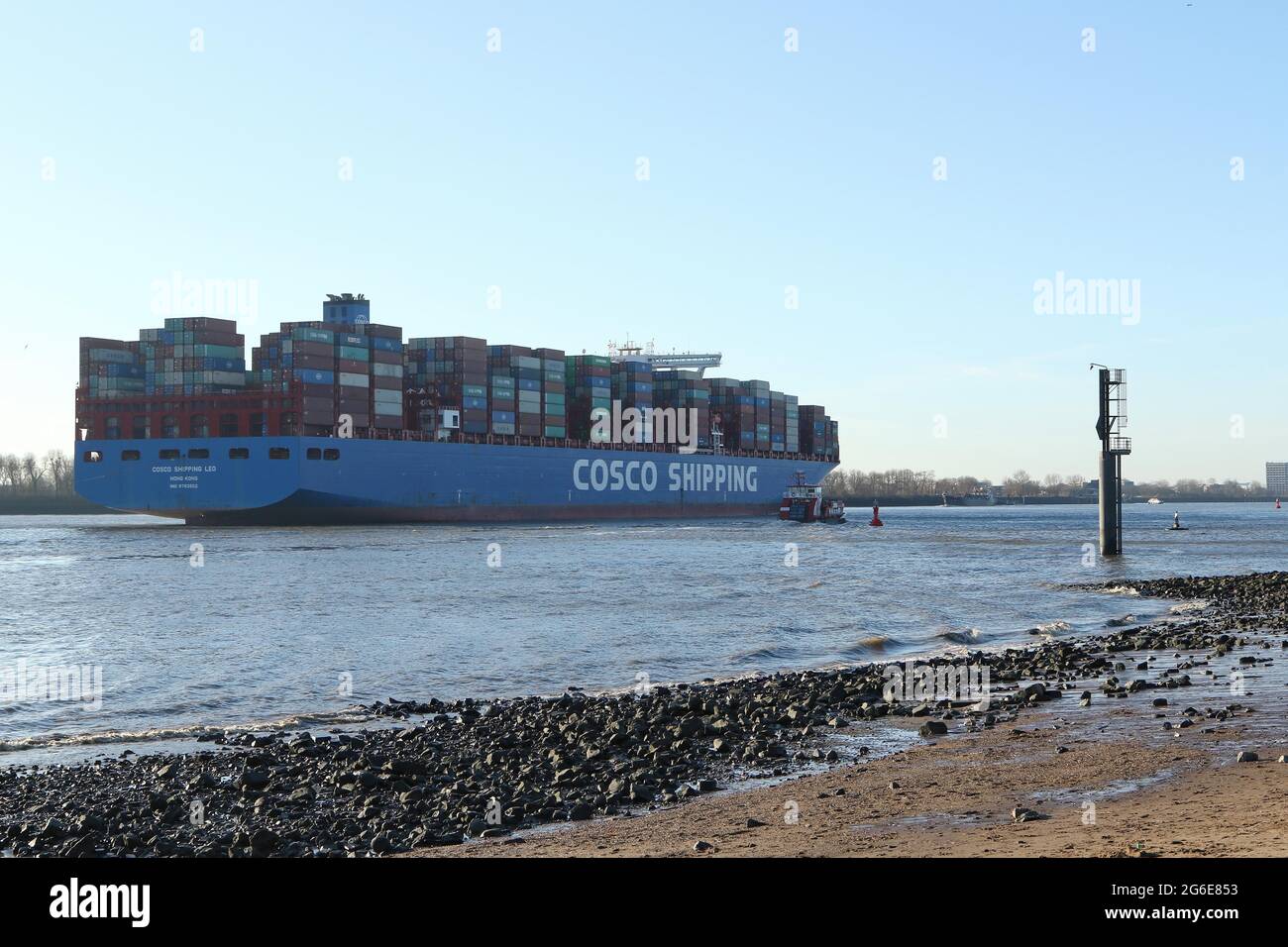 Container cargo nave della Cina Ocean Shipping Company COSCO lasciare il porto in una giornata di sole sul fiume Elba, Amburgo, Germania Foto Stock