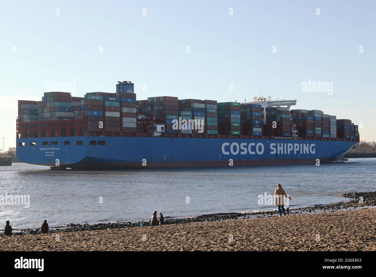 Container cargo nave della Cina Ocean Shipping Company COSCO lasciare il porto in una giornata di sole sul fiume Elba, Amburgo, Germania Foto Stock