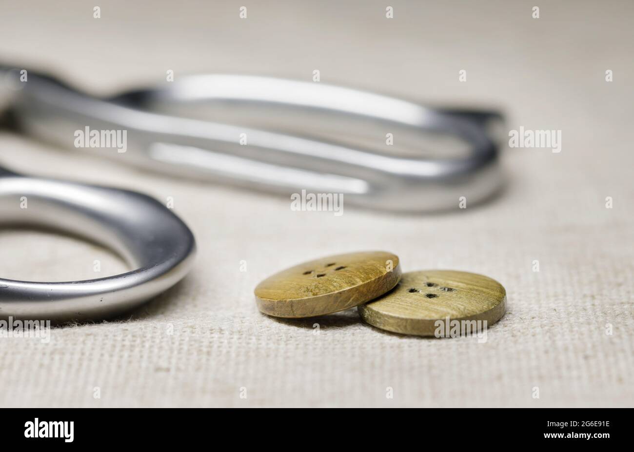 le forbici di tailor si trovano su un primo piano di scappone e bottoni di legno. Foto Stock
