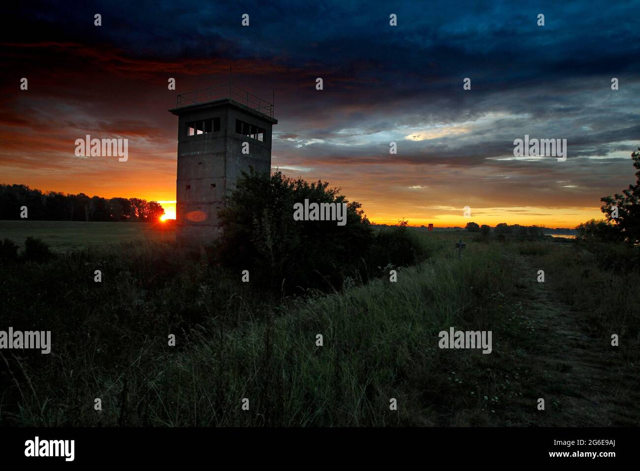 Alba, torre di osservazione delle truppe di confine della RDT, torre di guardia al tramonto, Elbe dyke, Kolonnenweg, Lochplattenweg, Inner-German Foto Stock