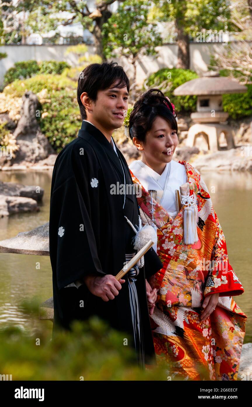 Foto di nozze di sposi e sposi nel giardino Yasuda a Toyko in Giappone. Il suo kimono broccato è indossato come cappotto sopra un kimono. Foto Stock