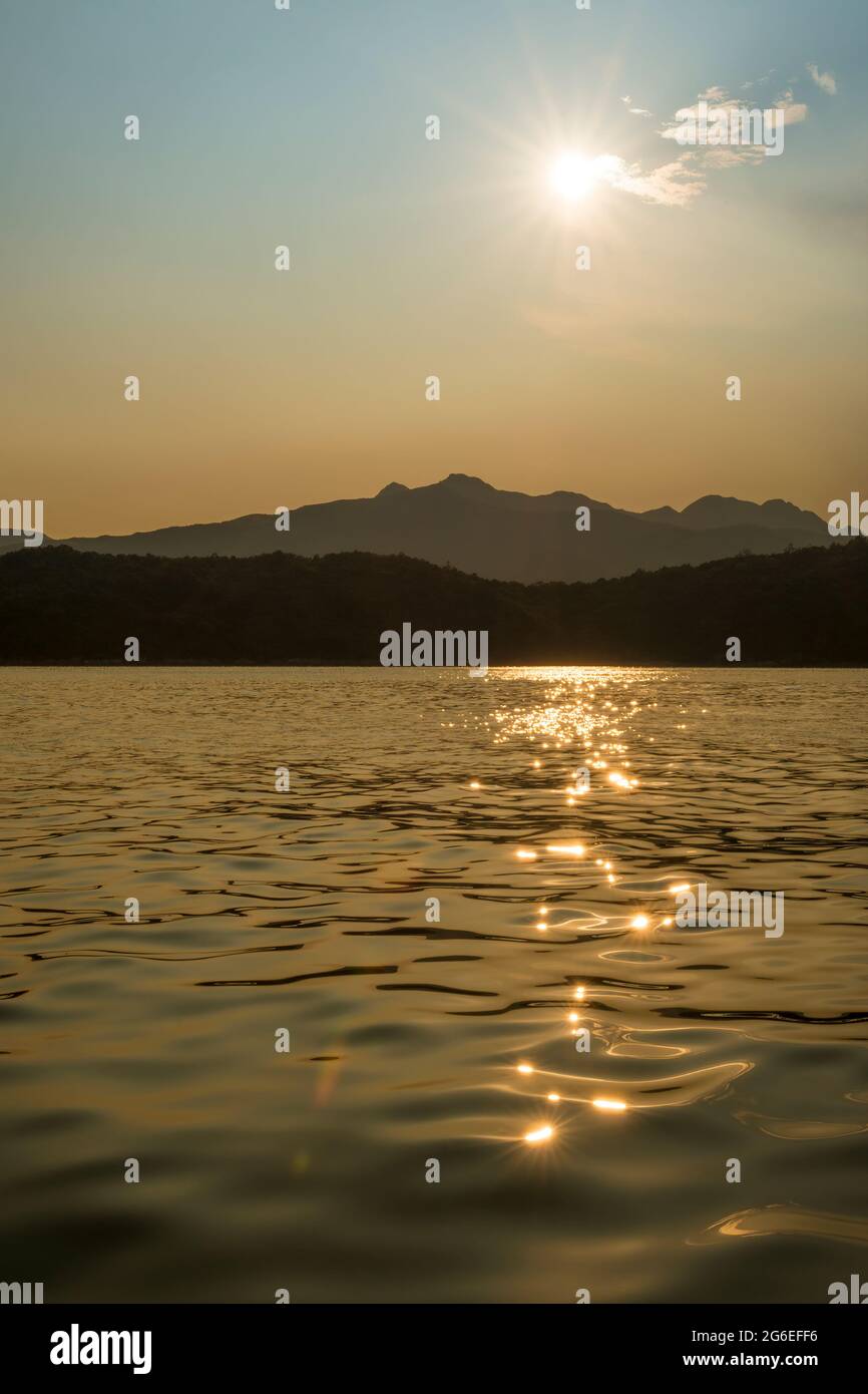 Il sole del tardo pomeriggio si riflette nelle acque di Port Shelter, Sai Kung, New Territories, Hong Kong Foto Stock