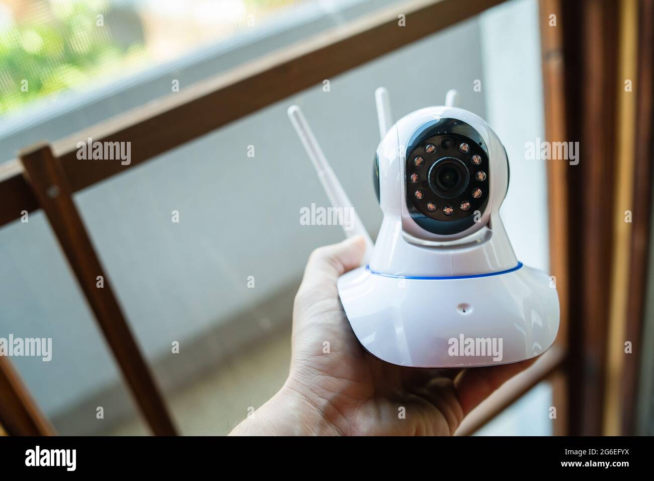 Primo piano su un uomo sconosciuto che tiene la telecamera di sorveglianza domestica Foto Stock