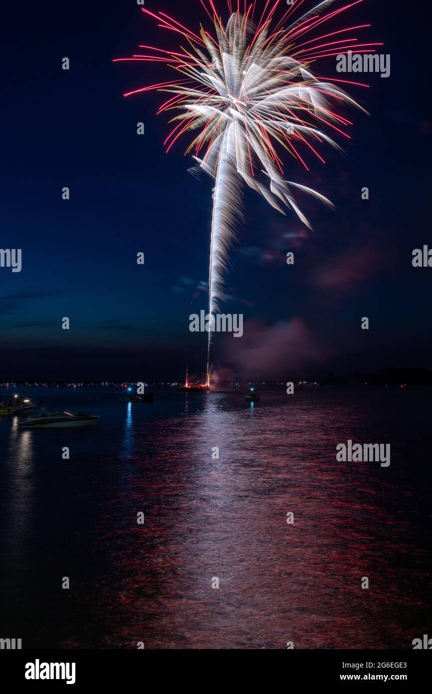 Fuochi d'artificio il 4 luglio sparato da una chiatta su un lago. Foto Stock