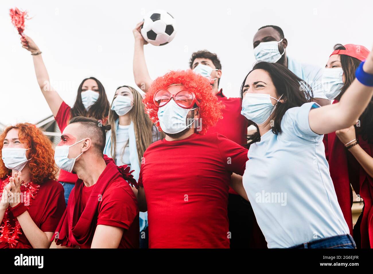 Amici multirazziali urlando e guardando una partita di calcio allo stadio Foto Stock