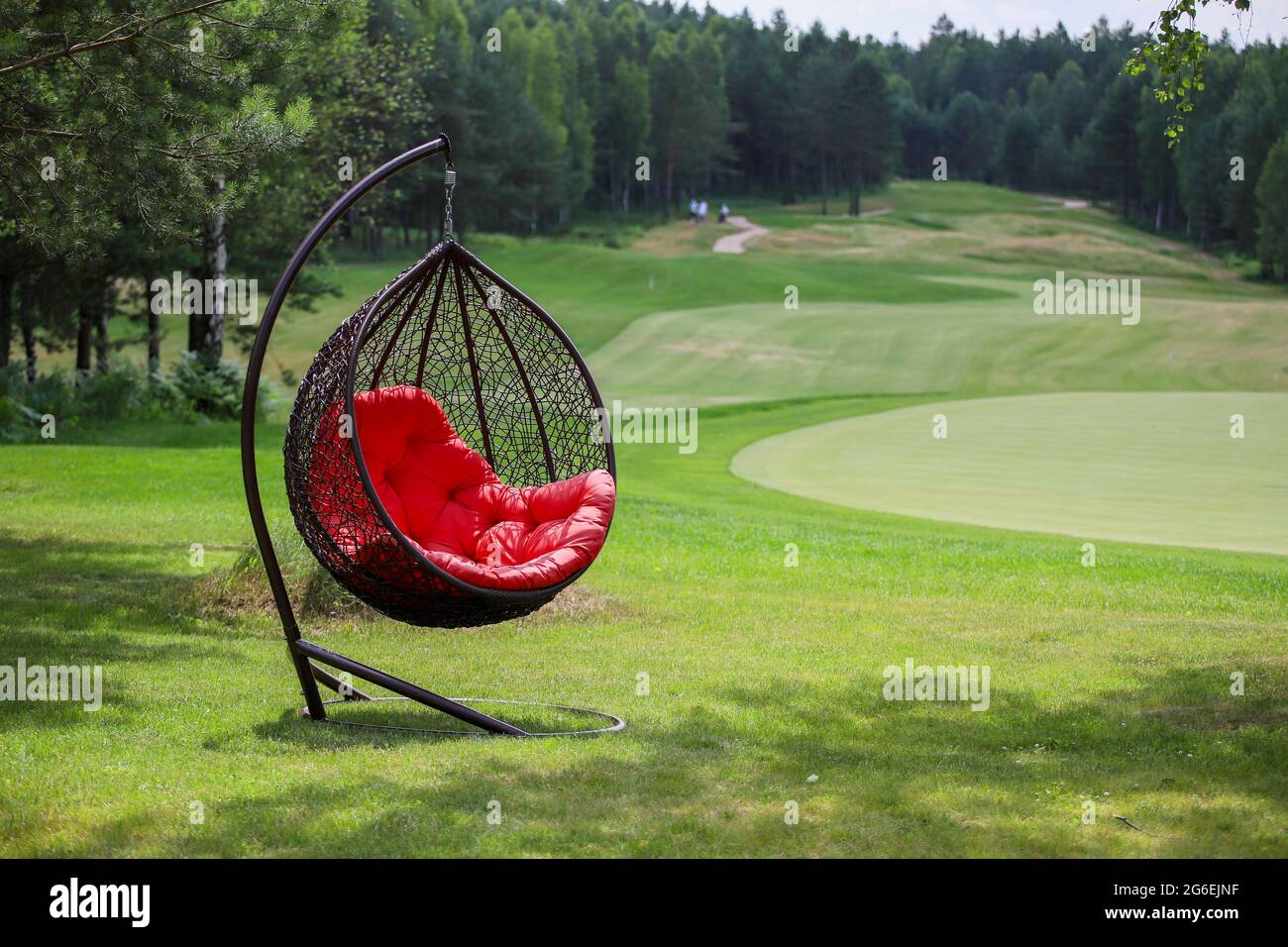 Sedia pensile con plaid rosso su un campo da golf. Foto Stock