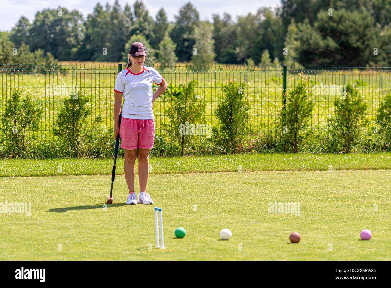 Ikskile, Lettonia - 4 luglio 2021: Una giovane donna che gioca croquet sul prato, concetto di attività familiare Foto Stock