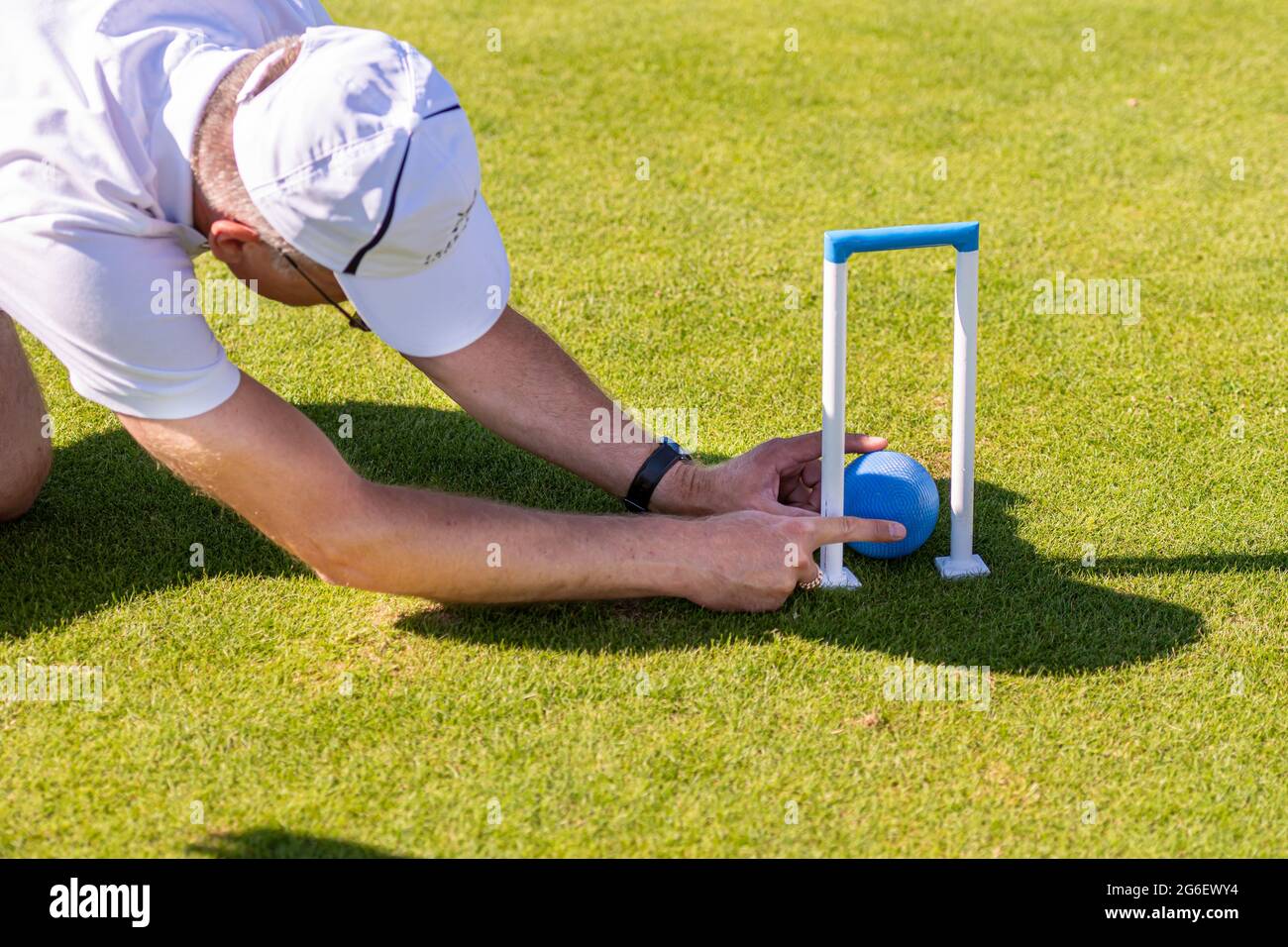 Ikskile, Lettonia - 4 luglio 2021: L'uomo valuta la situazione del gioco del croquet Foto Stock