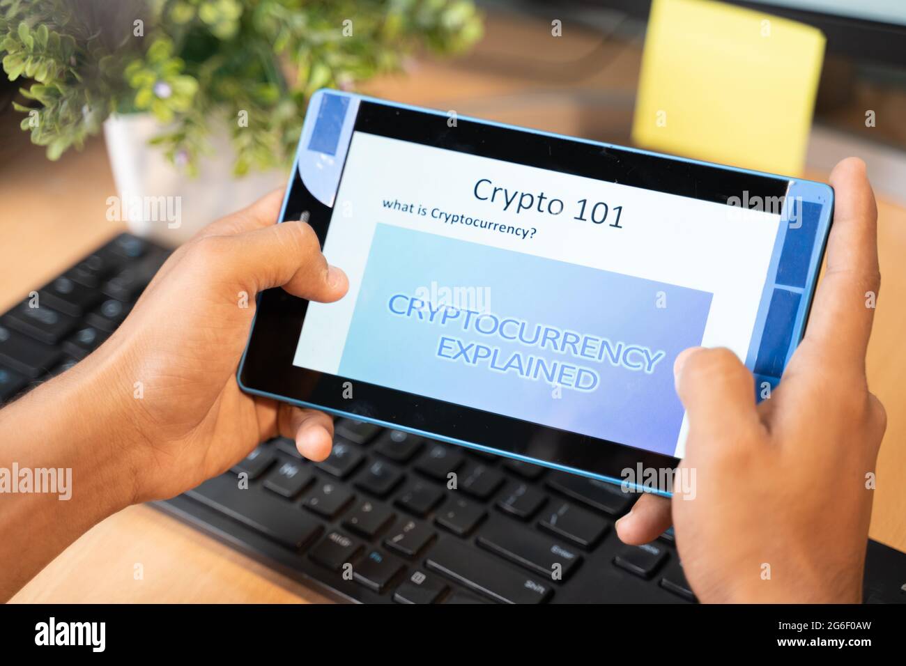Colpo di spalla di un uomo irriconoscibile che legge o impara circa la criptovaluta sul tablet. Foto Stock