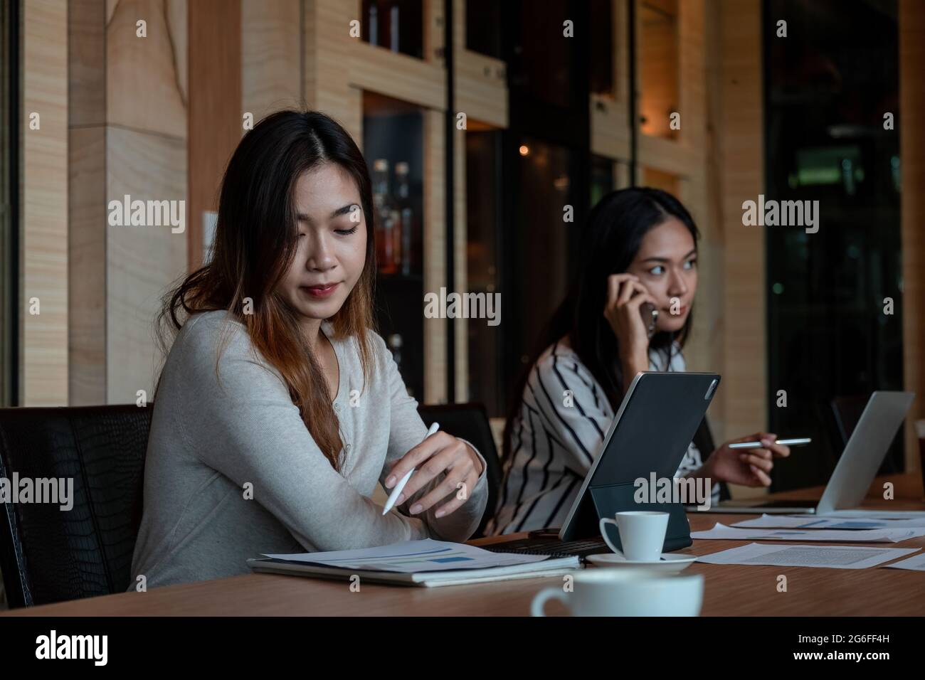 Colleghi che lavorano per le idee aziendali in un moderno spazio di lavoro cooperativo. Giovani asiatici che lavorano insieme Foto Stock