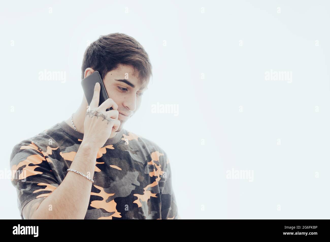 Giovane uomo che parla con il telefono cellulare Foto Stock