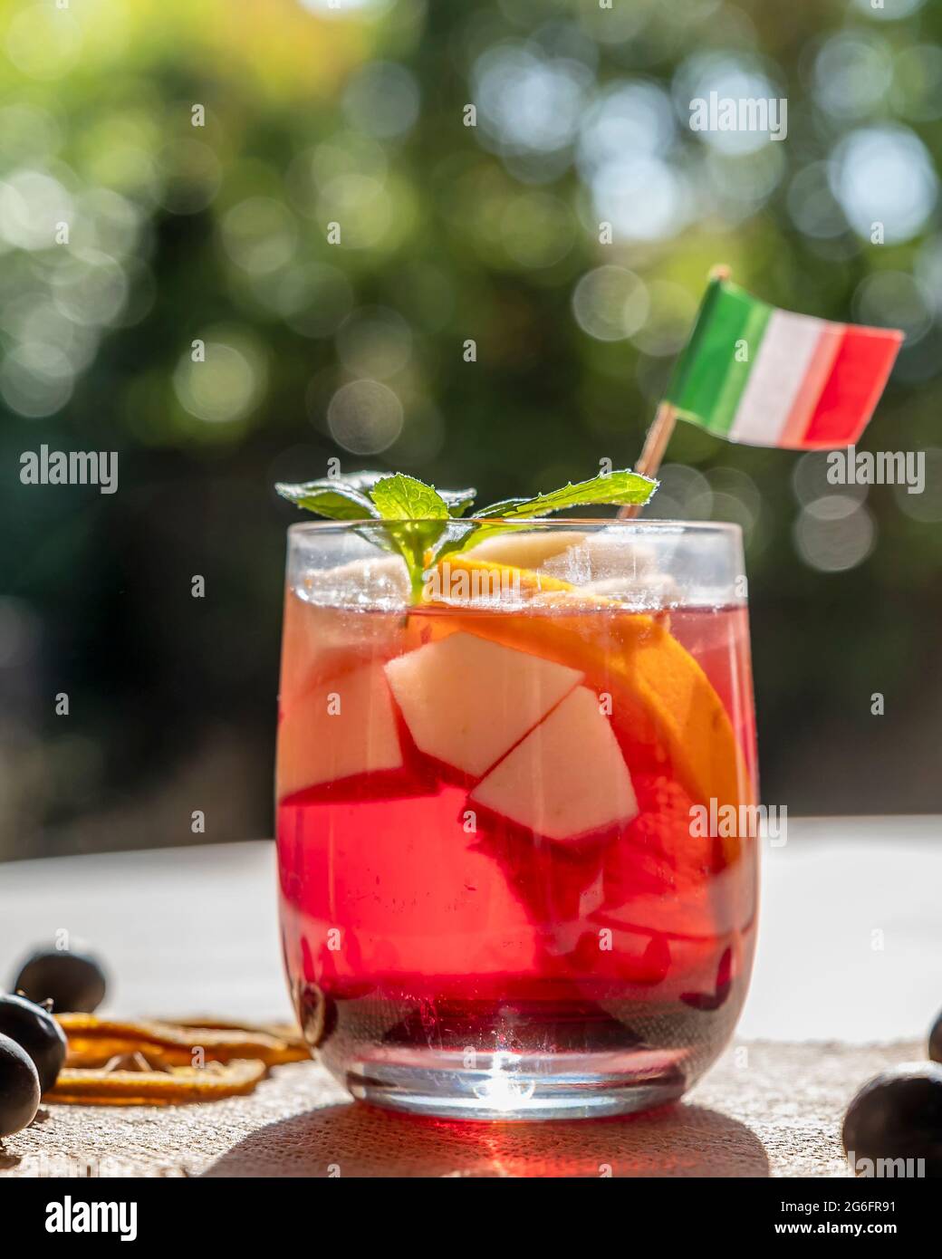 Un gustoso bicchiere di sangria con pezzi di frutta all'interno in controluce Foto Stock