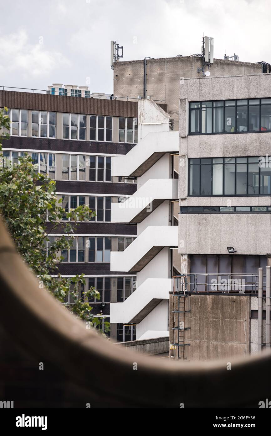 Scale di fuga fuoco all'angolo del vecchio edificio in cemento degli anni '70. Design simmetrico esterno per l'evacuazione dei residenti in caso di emergenza. Foto Stock