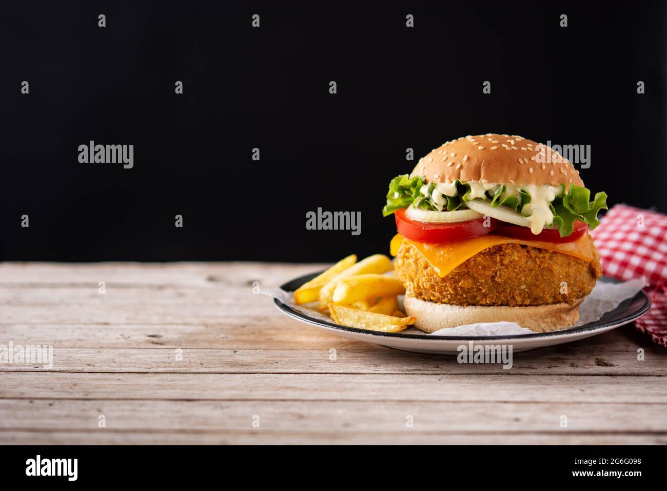 Hamburger di pollo croccante con formaggio su tavolo di legno Foto Stock